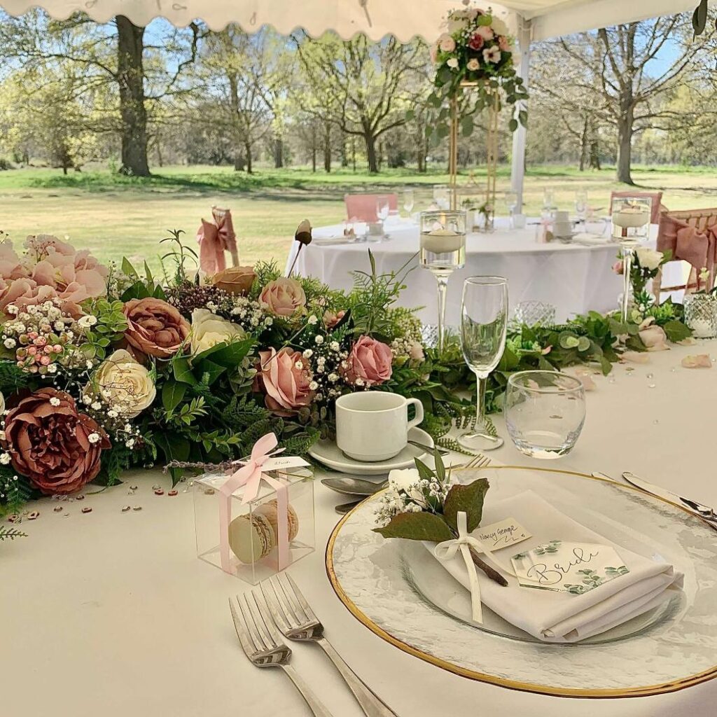 An outdoor wedding table in Oxfordshire, set with a dining set and adorned with flowers.